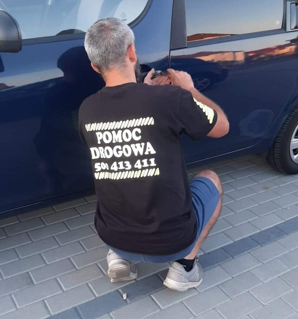 Awaryjne otwieranie samochodu w Koszalinie bez uszkodzeń, technik z narzędziem przy drzwiach auta.