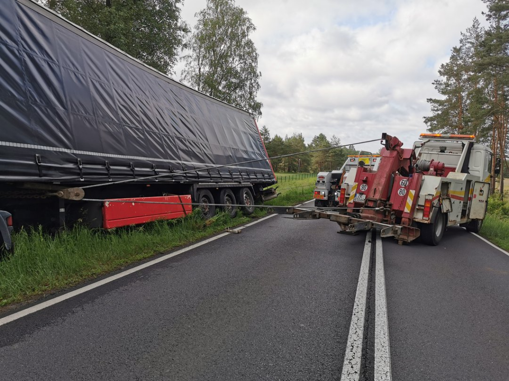 Akcja ratownicza z udziałem naczepy ciężarowej, która zsunęła się z drogi.